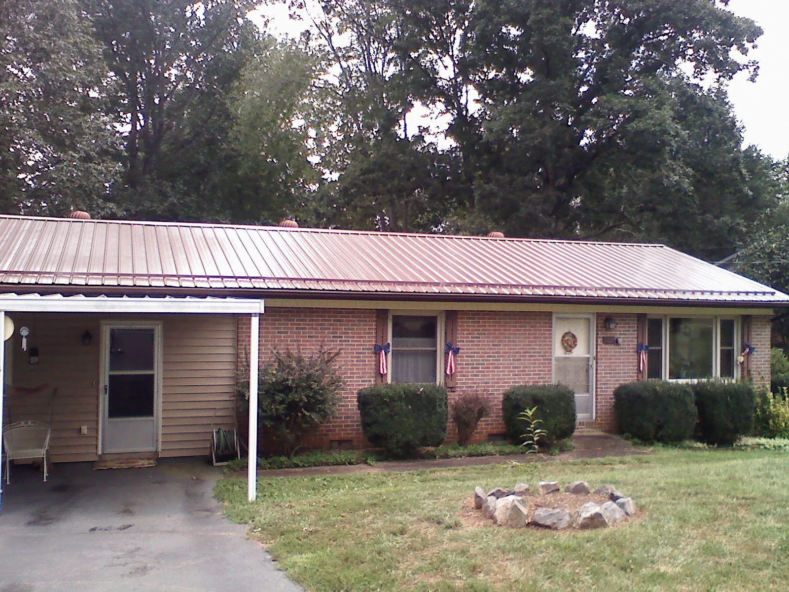 Bronze metal roof and carport on a brick ranch home — Roof Repair work by our crew in Mifflin