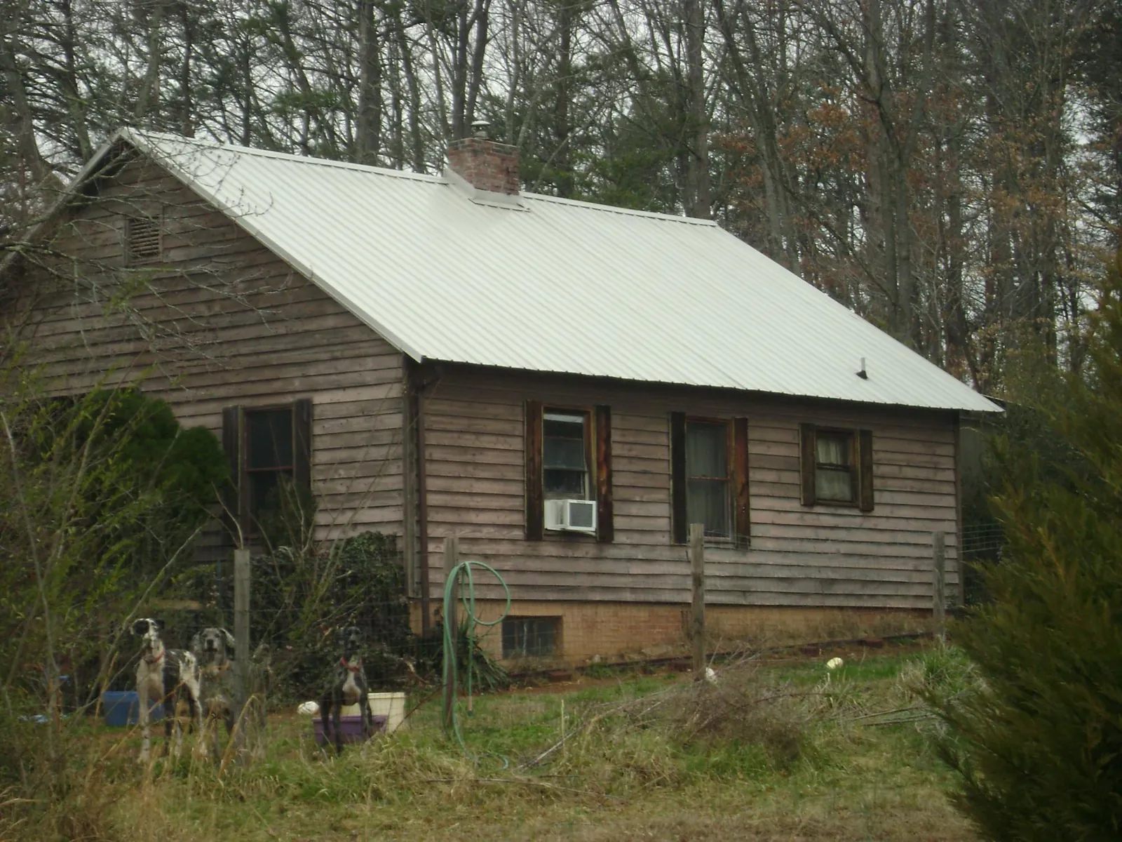 White metal roof on an old wood sided farmhouse, from a Metal Roof Installation job in Mifflin